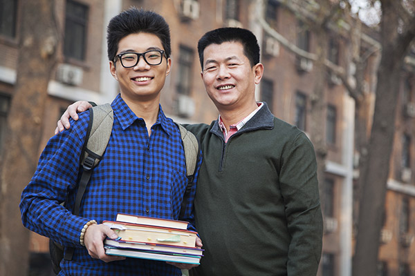 Image of a father and son in front of a college building.