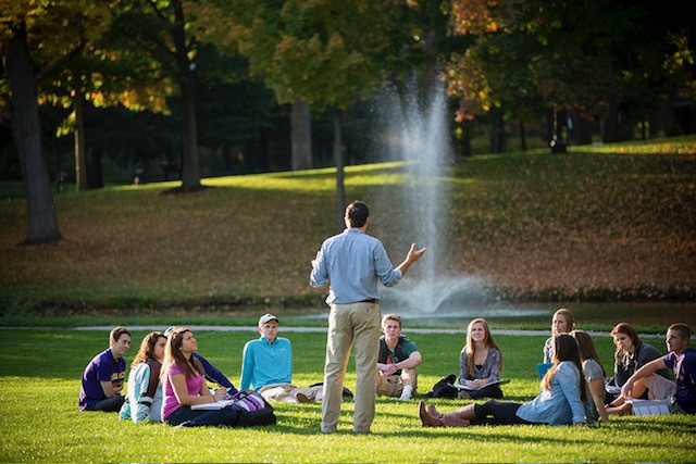 Elmira College: Students having class on the grass.