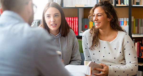 Image of high school students talking to a counselor. 